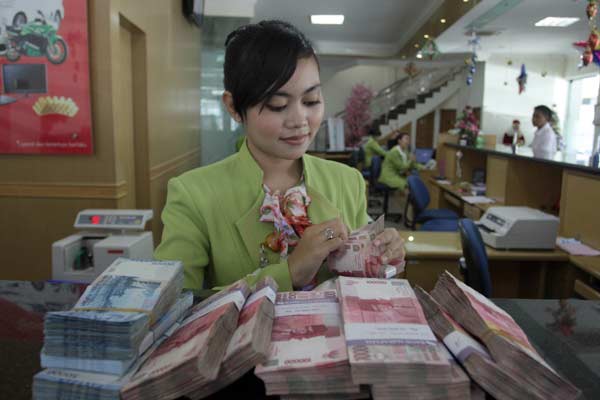 Kasir Bank Perkreditan Rakyat (BPR) menghitung uang rupiah. /Bisnis.com