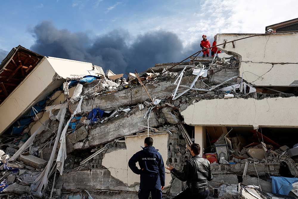 Warga mencari korban selamat di unit perawatan intensif rumah sakit negara Iskenderun yang runtuh setelah gempa bumi di Iskenderun, distrik Hatay, Turki, Selasa (7/2/2023). REUTERS/Benoit Tessier