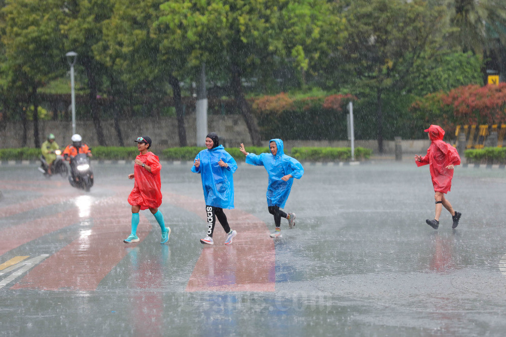 Warga melintas saat hujan di Jakarta, belum lama ini. Bisnis/Himawan L Nugraha