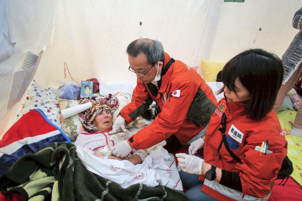 Dokter asal Jepang Toshihiko Toma (tengah) merawat seorang pasien di Osmaniye, Turki bagian Selatan, pada 22 Februari 2023. Anggota organisasi nirlaba TMAT yang berbasis di Tokyo berada di Turki yang dilanda gempa untuk memberi dukungan medis dan bergabung dalam operasi penyelamatan.Reuters/Kyodo