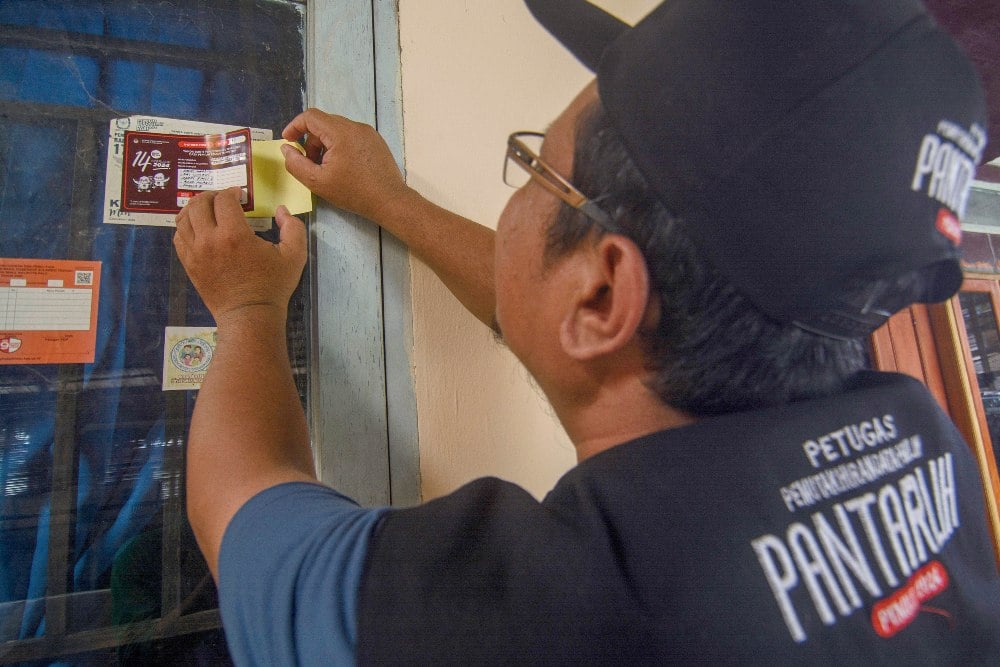Anggota Panitia Pemutakhiran Data Pemilih (Pantarlih) menempelkan stiker tanda sudah dilakukan pencocokan dan penelitian (Coklit) pemilih di rumah warga di Kelurahan Palupi, Palu, Sulawesi Tengah, Selasa (28/2/2023). Komisi Pemilihan Umum (KPU) setempat hingga kini telah melakukan pemutakhiran data pemilih melalui Coklit dengan menjangkau lebih dari 80 persen dari daftar pemilih sementara sehingga kegiatan itu dipastikan bisa selesai sesuai jadwal yaitu pada 15 Maret mendatang. ANTARA FOTO/Basri Marzuki/nym