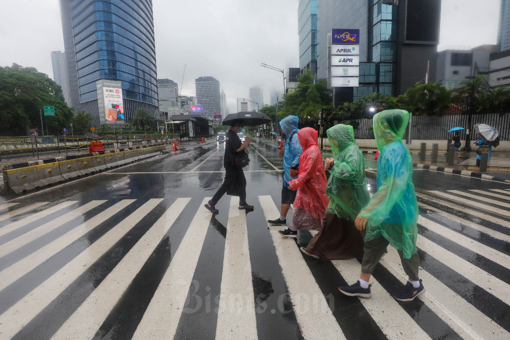 Warga melintas saat hujan di Jakarta. BMKG mengeluarkan peringatan dini cuaca di Jakarta pada Minggu (5/3/2023) berpotensi hujan disertai kilat dan angin kencang. Bisnis/Himawan L Nugraha