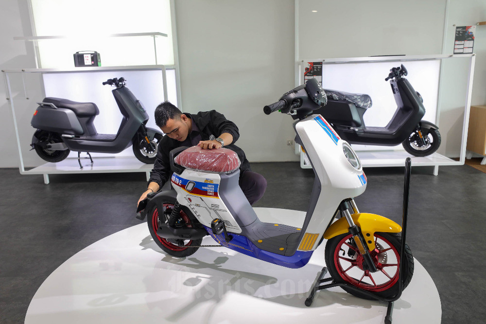 Pegawai merapikan sepeda motor listrik di salah satu ruang pamer/showroom, Jakarta, Senin (30/1/2023). Bisnis/Himawan L Nugraha