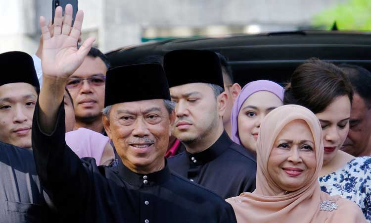 Perdana Menteri Malaysia Muhyiddin Yassin (kiri) melambaikan tangan sebelum berangkat untuk upacara pelantikan di Istana Nasional di Kuala Lumpur, Malaysia, Minggu (1/3/2020). Muhyiddin diangkat sebagai perdana menteri pada 29 Februari oleh raja negara itu untuk mengakhiri pergolakan enam hari perebutan kekuasaan setelah Mahathir Mohamad tiba-tiba mengundurkan diri pada hari Senin karena pertengkaran dalam koalisinya yang dulu. Bloomberg/Samsul Said