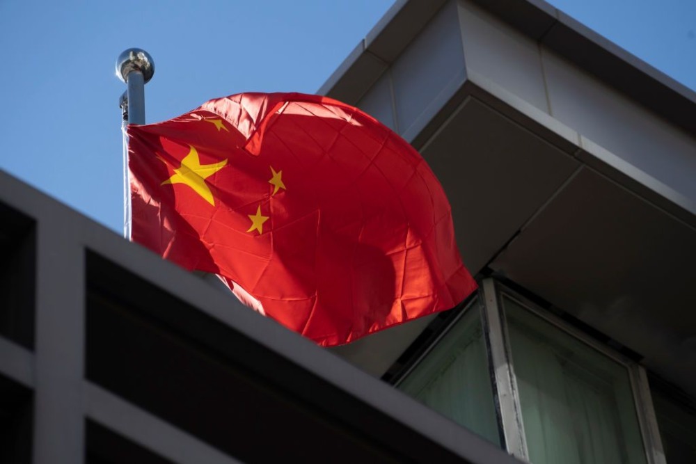 Bendera China berkibar di konsulat China setelah Amerika Serikat memerintahkan China untuk menutup pintunya pada 22 Juli 2020 di Houston, Texas. Menurut Departemen Luar Negeri, Pemerintah AS memerintahkan penutupan konsulat China untuk melindungi kekayaan intelektual dan informasi pribadi orang AS. Bloomberg/ Getty Images