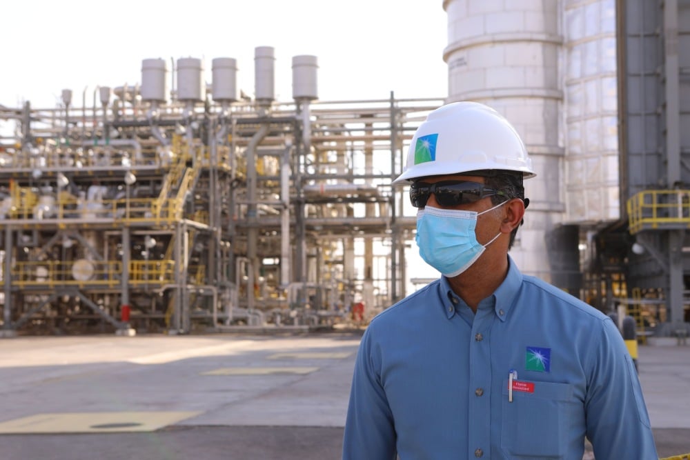 Pegawai Saudi Aramco berjalan di Departemen Pemrosesan Khurais yang terletak di ladang minyak Khurais, Arab Saudi, Senin (28/6/2021).Bloomberg/Maya Siddiqui