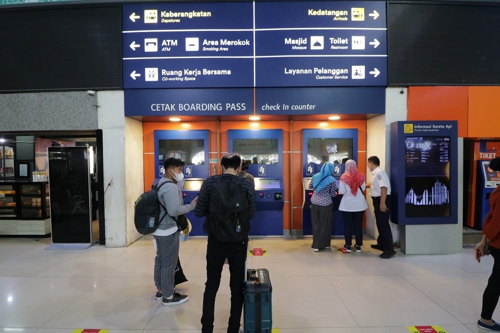 Penumpang Kereta Api Indonesia (KAI) antre mencetak tiket mandiri melalui Cetak Boarding Pass di Stasiun Bandung. 