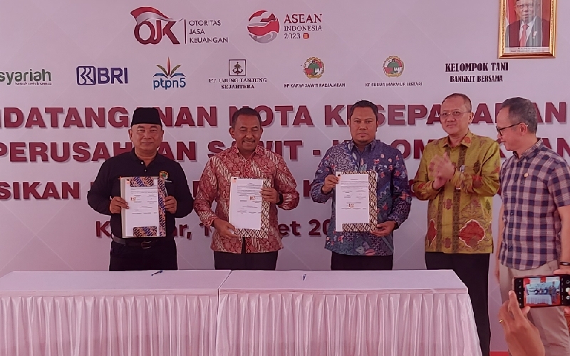 Dirut BRK Syariah Andi Buchari (kedua kanan) dan Ketua Dewan Komisioner OJK Mahendra Siregas (kanan) menyaksikan penandatanganan nota kesepahaman pembiayaan PSR dengan kelompok tani kelapa sawit di Kampar, Riau Jumat (17/3/2023)./Bisnis-Arif Gunawan