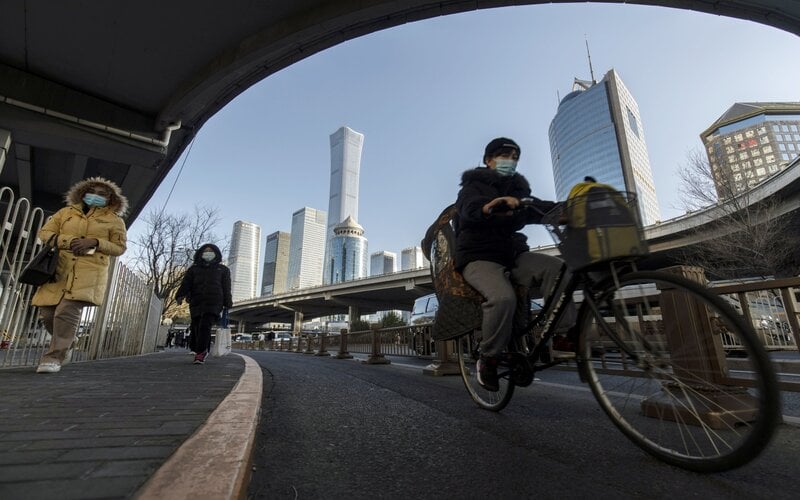 Pejalan kaki dan pesepeda di pusat distrik bisnis in Beijing, China, Selasa (23/11/2021)/ Bloomberg - Qilai Shen