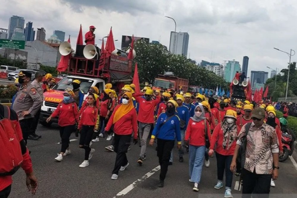 Massa buruh berjalan kaki menuntut pencabutan Peraturan Pemerintah Pengganti Undang-Undang Nomor 2 Tahun 2022 tentang Cipta Kerja (Perppu Cipta Kerja) di depan Gedung DPR RI, Senayan, Jakarta Pusat, Selasa (28/2/2023). ANTARA/Walda Marison/aa.
