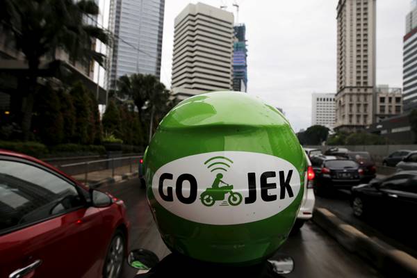 Pengemudi Gojek melintas di kawasan bisnis di Jakarta./Reuters