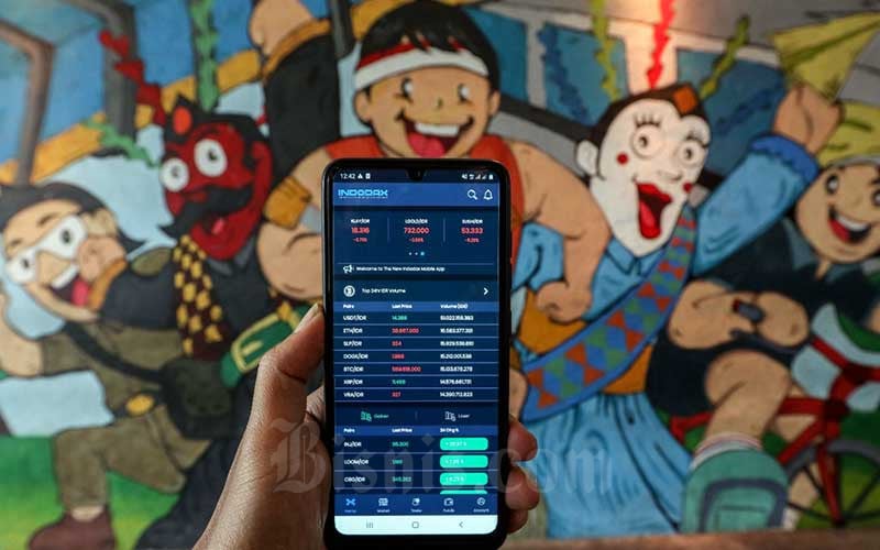 Investor memantau pergerakan harga kripto melalui ponselnya di Jakarta. Dalam sepekan terakhir, aset kripto bergerak naik.Bisnis/Eusebio Chrysnamurti