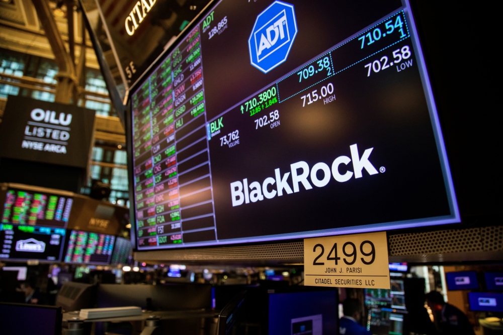Monitor dengan papan nama Blackrock Inc. di lantai New York Stock Exchange (NYSE) di New York, AS, pada Selasa, 15 Maret 2022. - Bloomberg/Michael Nagle
