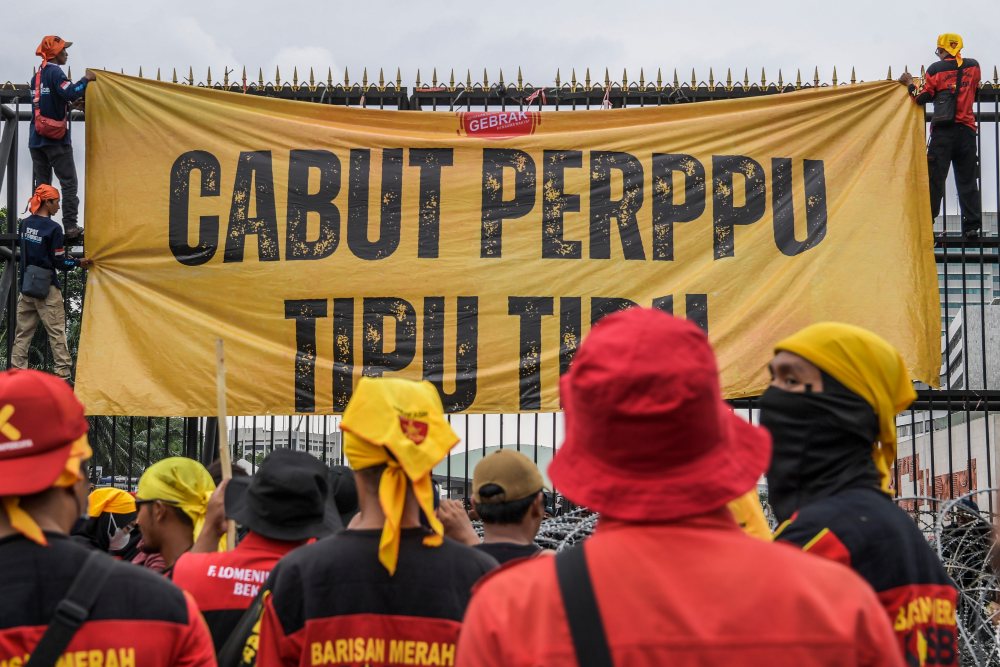 PDIP Minta Mahasiswa Kritisi Pengesahan Perppu Cipta Kerja Tak Lewat Umpatan. Pengunjuk rasa membentangkan spanduk saat berunjuk rasa di depan Gedung DPR, Senayan, Jakarta, Selasa (14/3/2023). Unjuk rasa yang diikuti serikat buruh, mahasiswa, dan petani itu menuntut pemerintah untuk segera mencabut Peraturan Pemerintah Pengganti Undang-Undang (Perppu) Nomor 2 Tahun 2022 tentang Cipta Kerja. ANTARA FOTO/Galih Pradipta/tom.