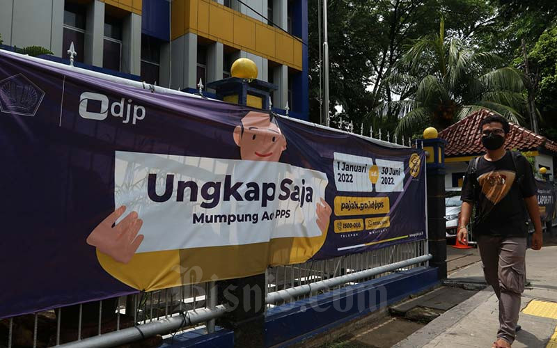 Warga melintasi spanduk Program Pengungkapan Sukarela (PPS) di salah satu kantor pelayanan pajak pratama di Jakarta, Senin (17/1/2022). Bisnis/Eusebio Chrysnamurti