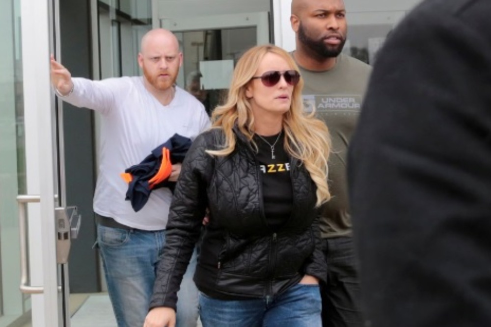 Bintang film dewasa Stormy Daniels, yang nama aslinya adalah Stephanie Clifford, dan petugas keamanannya meninggalkan Departemen Kepolisian Detroit 4th Precinct setelah mengambil lisensi Dance Permit sementara untuk tampil di sebuah klub di Detroit, Michigan, Amerika Serikat, 18 April 2018. REUTERS/ Rebecca Cook
