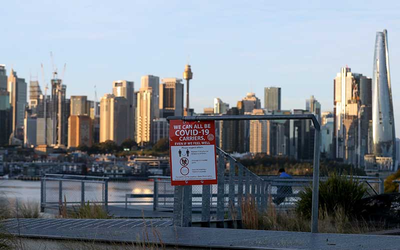 Papan pemberitahuan yang memperingatkan Kita semua bisa menjadi pembawa Covid-19 berada di tempat publik di Sydney, Australia, Selasa (27/7/2021). Setelah sebulan melakukan Lockdown, kasus harian Covid-19 di kota Sydney tidak menunjukkan tanda-tanda mereda. Bloomberg/Brendon Thorne
