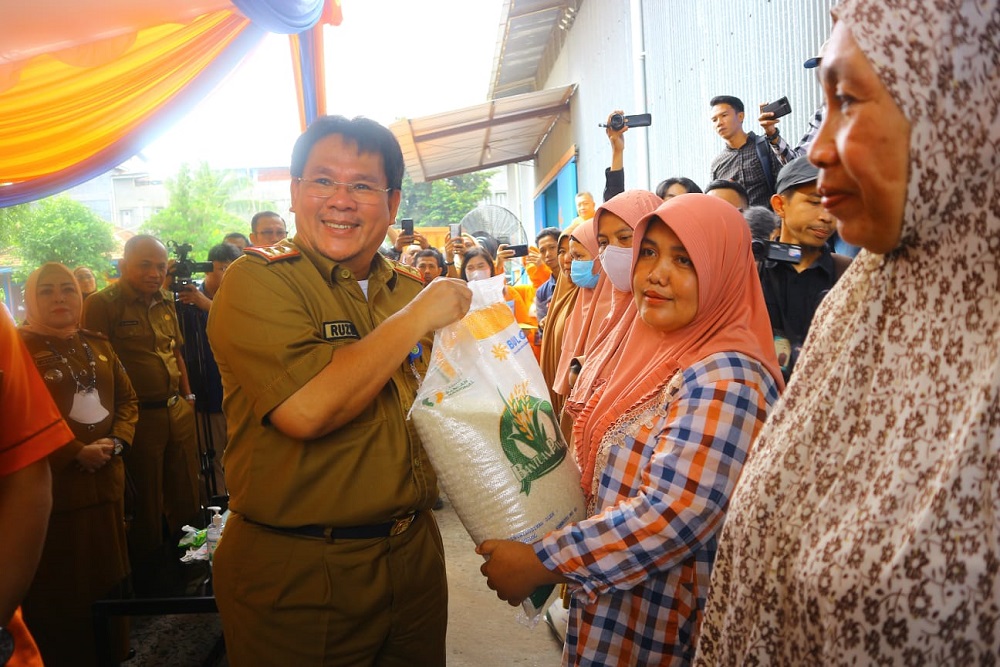 Penyerahan bantuan beras oleh Kepala Dinas Ketahanan Pangan dan Peternakan Sumsel Ruzuan Effendi (kiri) kepada masyarakat miskin wilayah Sumsel, Selasa (4/4/2023). /Bisnis-Husnul Iga Puspita
