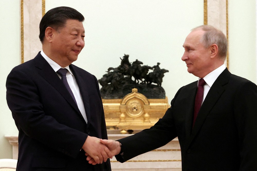 Presiden Rusia Vladimir Putin berjabat tangan dengan Presiden China Xi Jinping selama pertemuan di Kremlin di Moskow, Rusia, 20 Maret 2023. Sputnik/Sergei Karpukhin/Pool via REUTERS
