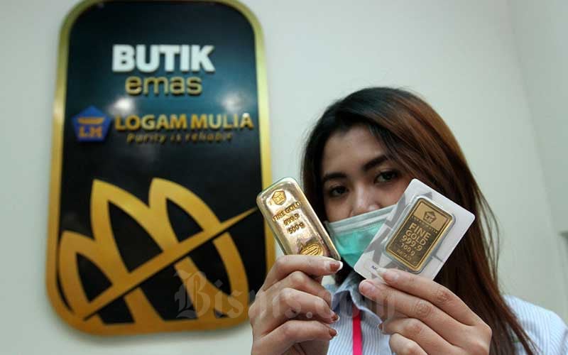 Karyawati menunjukkan replika logam mulia di Butik Emas Antam, Jakarta, Kamis (6/8/2020). Bisnis/Arief Hermawan P