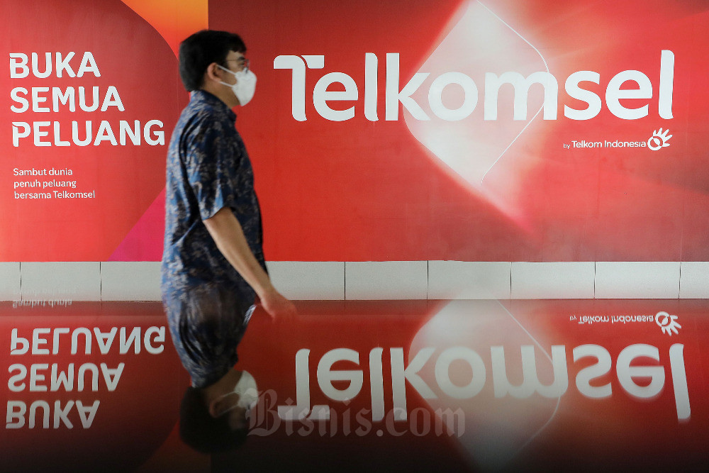 Produk Hasil Merger IndiHome dan Telkomsel Hadir Agustus 2023. Warga melintasi iklan Telkomsel di Jakarta, Selasa (11/10/2022). Bisnis/Eusebio Chrysnamurti