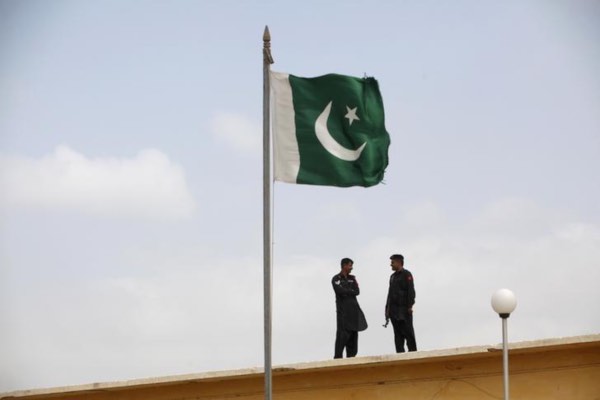 Tentara Pakistan berbincang di dekat bendera Pakistan yang berkibar di penjara Karachi, Pakistan, Jumat (23/8/2013)./Reuters-Akhtar Soomro