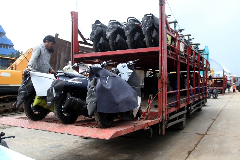 Pekerja memindahkan sepeda motor yang baru diturunkan dari kapal untuk dikirim ke dealer di Pelabuhan Makassar, Sulawesi Selatan, Selasa (28/3/2023)/Bisnis-Paulus Tandi Bone