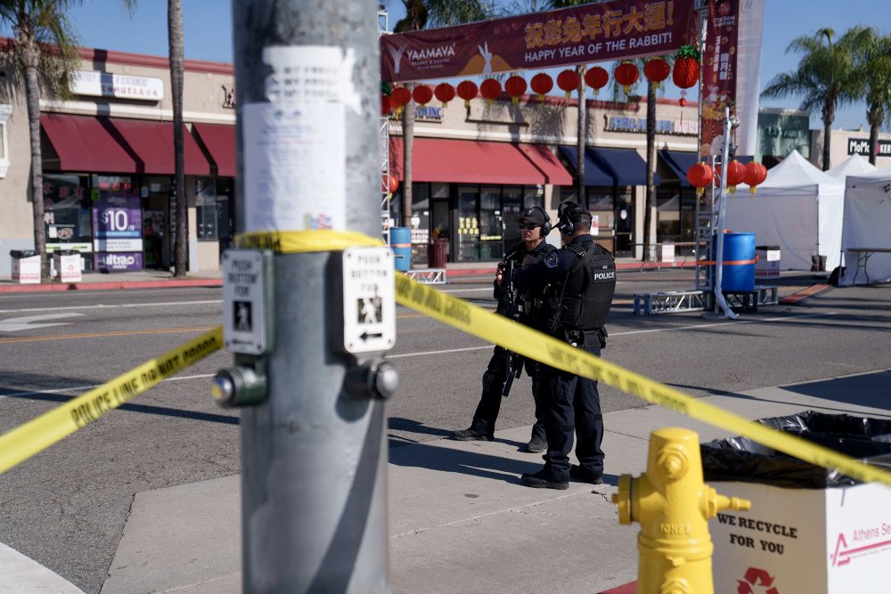 Petugas polisi berjaga di dekat lokasi penembakan mematikan di Monterey Park, California, Minggu (22/1/2023)/Bloomberg