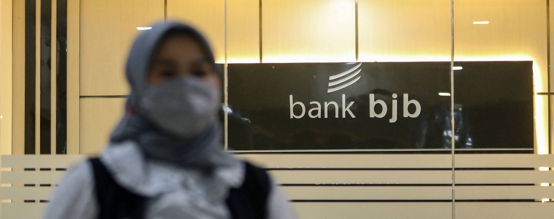 Nasabah melintasi logo Bank BJB di Jakarta./Bisnis - Eusebio Chrysnamurti