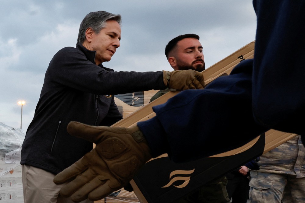 Menteri Luar Negeri AS Antony Blinken membantu personel militer AS membawa bantuan di Pangkalan Udara Incirlik dekat Adana, Turki 19 Februari 2023. REUTERS/Clodagh Kilcoyne/Pool