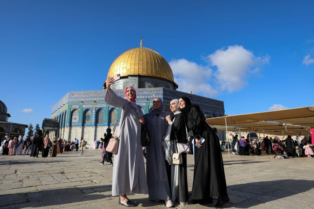 Perempuan Palestina berswafoto bersama setelah salat Id di kompleks yang menaungi masjid Al-Aqsa, Yerusalem, Palestina, 21 April 2023./Reuters