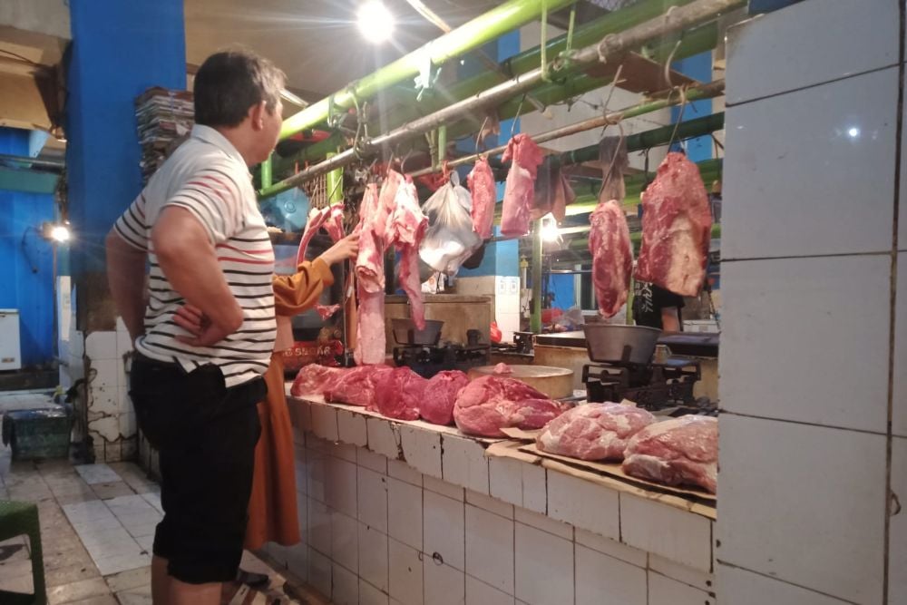 Pedagang menjual daging impor Perum Bulog di Pasar Jatinegara, Jakarta, Jumat (21/4/2023) - BISNIS/Indra Gunawan.