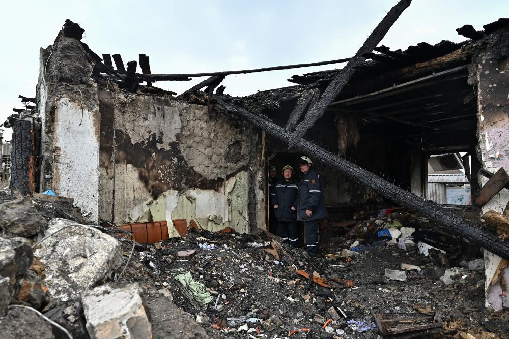 Tim penyelamat terlihat di dalam rumah penduduk yang hancur akibat serangan rudal Rusia di tengah serangan Rusia di Ukraina di Zaporizhzhia, Ukraina 9 April 2023. REUTERS/Stringerrn