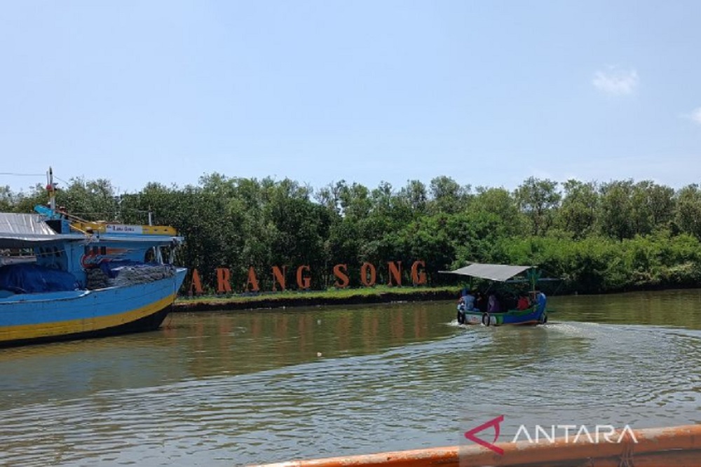 Wisatawan saat menggunakan perahu menuju kawasan hutan mangrove di Pantai Karangsong, Kabupaten Indramayu, Jawa Barat, Minggu (23/4/2023). /Antara