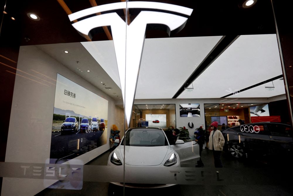 Pengunjung melihat-lihat mobil Tesla Model 3 di samping Model Y yang dipajang di showroom Tesla di Beijing, China, 4 Februari 2023./Reuters-Florence Lo