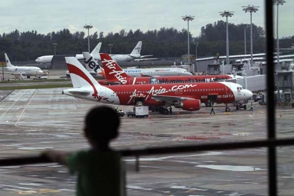 Seorang anak memperhatikan sejumlah pesawat AirAsia (CMPP) yang tengah parkir di Bandara Intenasional Changi di Singapura/Reuters-Edgar Su