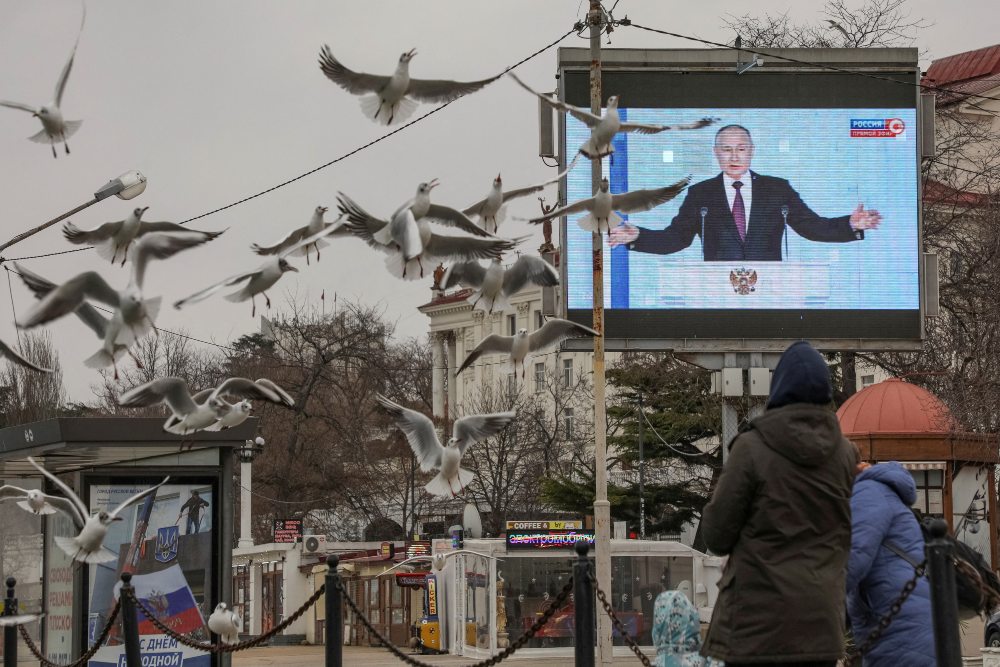 Presiden Rusia Vladimir Putin terlihat di layar selama pidato tahunannya di Majelis Federal, di Sevastopol, Krimea, 21 Februari 2023. REUTERS/Alexey Pavlishak 