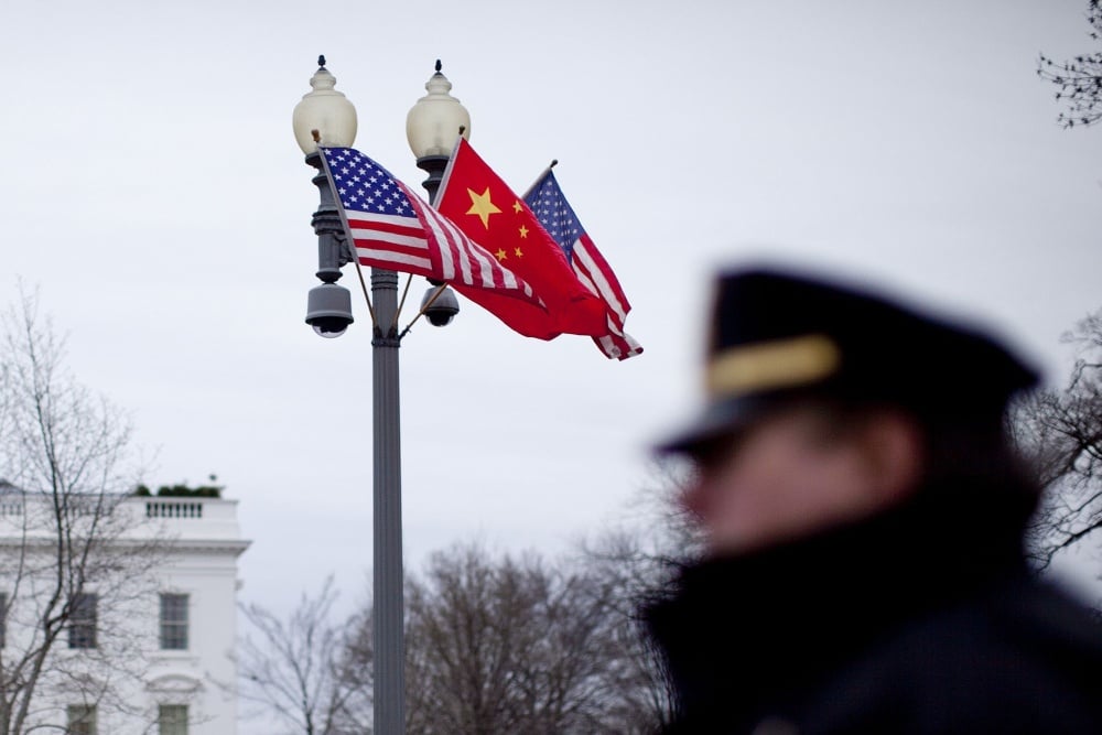 Bendera Amerika Serikat dan China berkibar di luar Gedung Putih saat anggota Secret Service berjaga di Washington, D.C., AS, pada Senin, 17 Agustus 2011. Hu Jintao, Presiden China, tiba di Washington untuk kunjungan kenegaraan pertamanya ke AS./Bloomberg