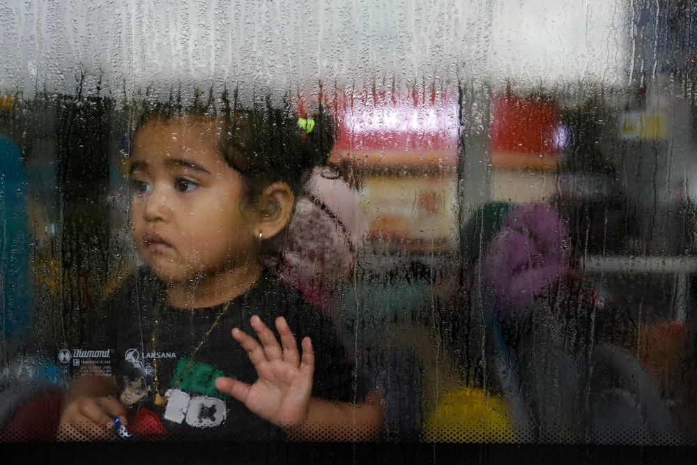 Seorang gadis yang dievakuasi dari Sudan melihat melalui jendela bus setelah dia tiba di Bandara Soekarno-Hatta di Tangerang, di pinggiran Jakarta, Indonesia, 28 April 2023. REUTERS/Ajeng Dinar Ulfiana