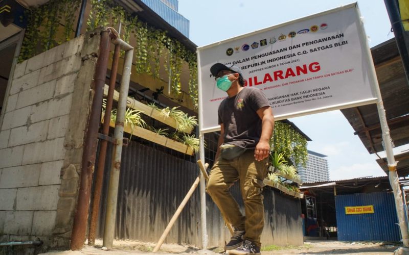 Warga melintas di dekat plang pengaman yang di pasang satgas untuk menguasai aset tanah eks BLBI di Karet Tengsin. Satuan Tugas (Satgas) BLBI telah menyita tanah seluas 26.928,9 m2 milik eks debitur Bantuan Likuiditas Bank Indonesia (BLBI) PT Sinar Bonana Jaya eks Bank Yakin Makmur (YAMA) di Karet Tengsin, Jakarta Pusat. Penyitaan itu adalah salah satu upaya Satgas BLBI untuk mengamankan aset-aset eks debitur maupun obligor BLBI supaya bisa dikelola secara optimal./BISNIS-Suselo Jati