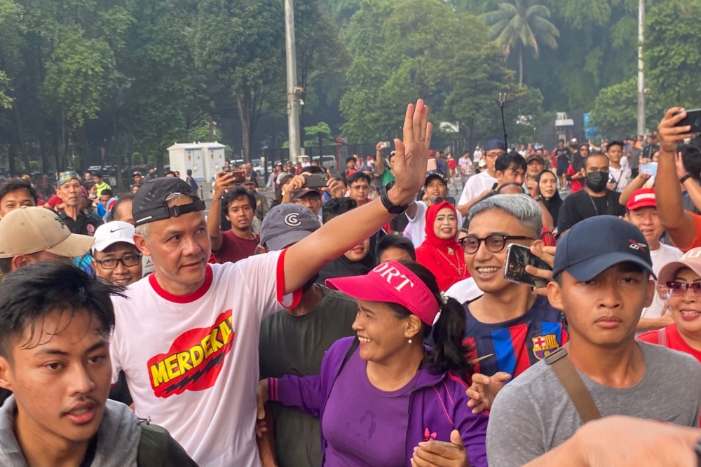 Ganjar Pranowo menjadi sasaran swafoto pengunjung CFD saat lari pagi di Gelora Bung Karno, Minggu (30/4/2023) pagi. /Bisnis-Akbar Evandio