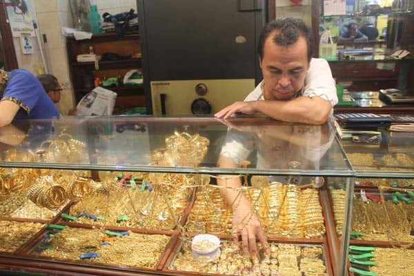 Seorang  pegawai toko emas di Pasar Sentral Antasari Banjarmasin, Kalimantan Selatan sedang menyusun emas perhiasan Senin (1/10/2018)./Bisnis-Arief Rahman