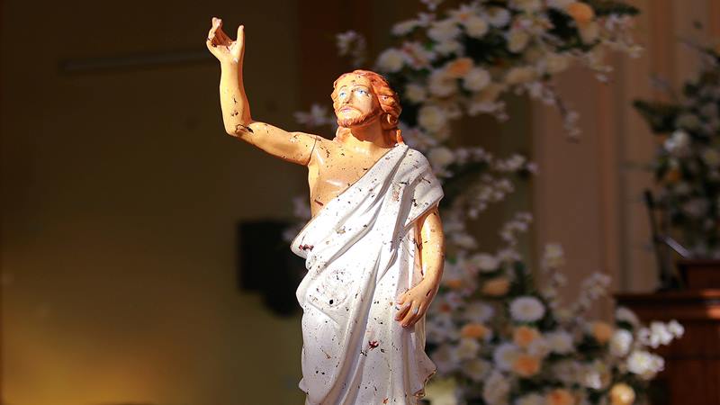 Patung Yesus Kristus tampak terciprat darah ketika sinar Matahari masuk melalui atap yang hancur di dalam Gereja St Sebastian di Negombo, Sri Lanka 21 April 2019./ Reuters