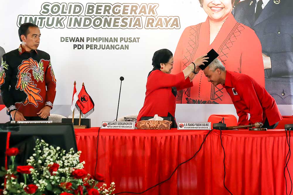 Ketua Umum PDI Perjuangan Megawati Soekarnoputri (tengah) menyematkan peci kepada calon Presiden 2024 yang diajukan PDI Perjuangan Ganjar Pranowo (kanan) disaksikan Presiden Joko Widodo (kiri) di Istana Batu Tulis, Bogor, Jawa Barat, Jumat (21/4/2023). PDI Perjuangan resmi menetapkan Gubernur Jawa Tengah Ganjar Pranowo sebagai calon presiden 2024. ANTARA FOTO/Monang