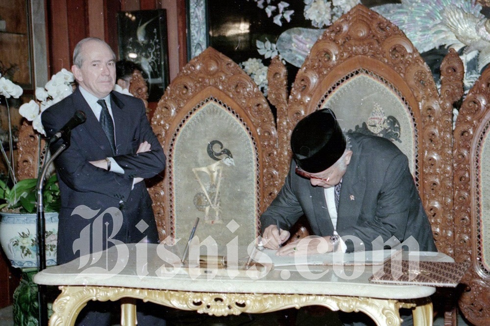 Presiden ke-2 RI Soeharto tengah menandatangani komitmen pinjaman dari Dana Moneter Internasional (IMF) dengan disaksikan Michel Camdessus, Managing Director IMF, pada 15 Januari 1998, empat bulan sebelum penguasa Orde Baru itu lengser, 21 Mei 1998./Bisnis