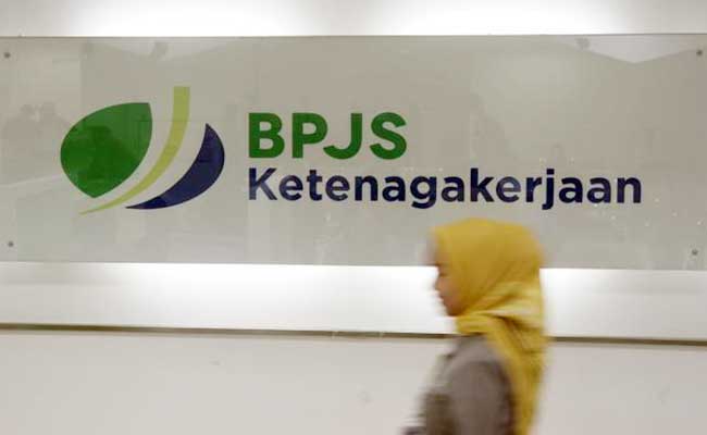 Karyawan melintas di dekat logo BPJS Ketenagakerjaan/BP Jamsostek di Jakarta. Bisnis/Himawan L Nugraha