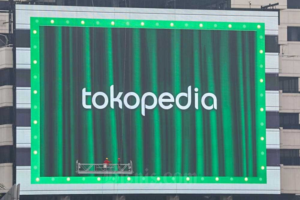 Pekerja melakukan perawatan videotron yang menampilkan iklan Tokopedia di Jakarta, Selasa (11/10/2022). Bisnis/Himawan L Nugraha