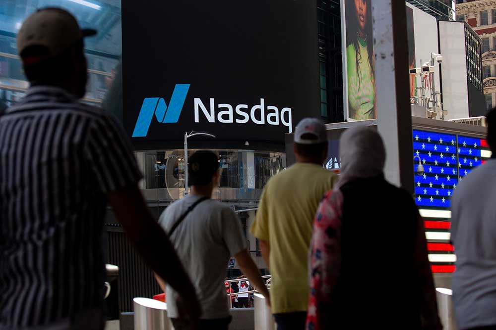 Pejalan kaki melintas di depan Nasdaq MarketSite di New York, AS, Rabu (15/6/2022). Bloomberg/Michael Nagle