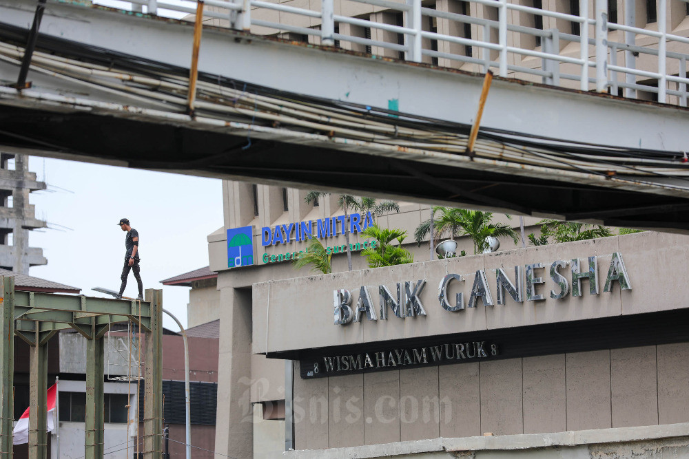 Pekerja beraktivitas di dekat logo Bank Ganesha di Jakarta, Kamis (5/1/2023). Bisnis/Himawan L Nugraha