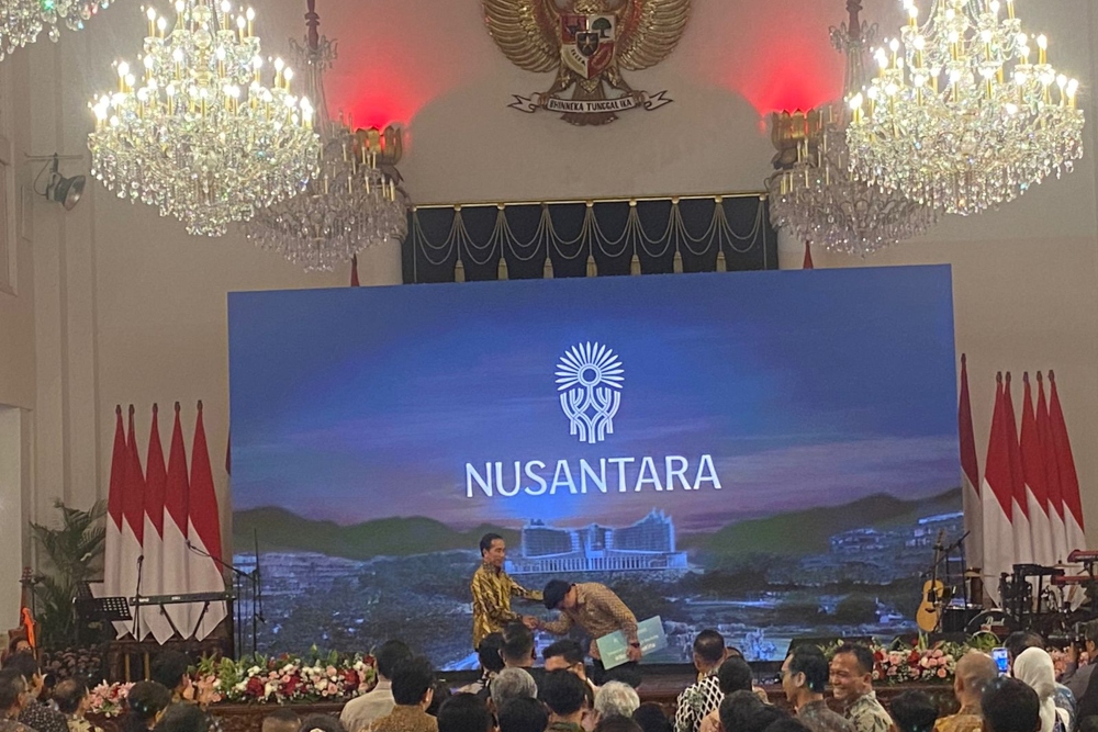 Presiden Jokowi memberi selamat kepada Aulia Akbar desainer logo Pohon Hayat yang menjadi logo resmi IKN di Istana Negara, Selasa (30/5/2023) - BISNIS/Akbar Evandio